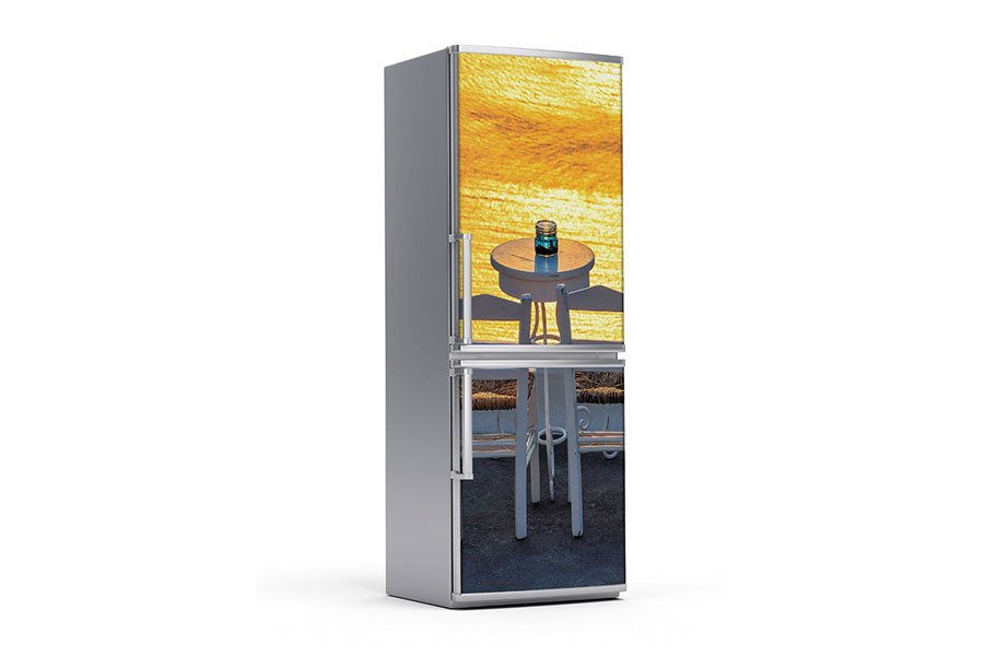 Υφασμάτινο αυτοκόλλητο ψυγείου που απεικονίζει ένα τραπεζάκι με δύο καρέκλες που βλέπουν προς το ηλιοβασίλεμα της Σαντορίνης.Είναι ανθεκτικό και κολλάει και ξεκολλάει εύκολα.Μπορείτε να μας ζητήσετε να εκτυπωθεί σε όποιες διαστάσεις θέλετε. Το θέμα προσαρμόζεται αναλογικά στις διαστάσεις που θέλετε.Το παράδειγμα που παρουσιάζουμε στην απομονωμένη εικόνα του θέματος αφορά ψυγείο με διαστάσεις 75cm πλάτος x 200cm ύψος.