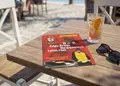 Flyer με ζωντανά χρώματα και οργανωμένη διάταξη, προβάλει καλοκαιρινές προσφορές, ιστορικό παραθαλάσσιου προορισμού.