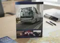 Τρίπτυχο διαφημιστικό έντυπο με ζωντανά γραφικά και λεωφορείο.