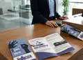 Πολύπτυχη μπροσούρα με ζωντανά χρώματα και γραφικά σε κόκκινο φόντο.