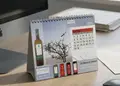 Τριγωνικό επιτραπέζιο ημερολόγιο με θέμα κρασί, σε γραφείο.