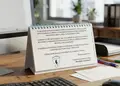Επιτραπέζιο τριγωνικό ημερολόγιο με μεταλλικό σπιράλ και ζωντανά χρώματα, ιδανικό για γραφείο.
