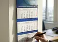 Ημερολόγιο τοίχου με τριμηνιαία προβολή και κόκκινες Κυριακές σε επαγγελματικό περιβάλλον