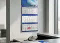 Ημερολόγιο τοίχου με τριμηνιαία προβολή και κόκκινες Κυριακές σε επαγγελματικό περιβάλλον