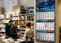 Τρίμηνο ημερολόγιο τοίχου με προσαρμοσμένο λογότυπο σε φωτεινό περιβάλλον