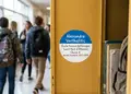 Αυτοκόλλητο στρογγυλού σχήματος με ζωντανά μπλε και κίτρινα χρώματα, ιδανικό για ετικέτες και προωθήσεις.