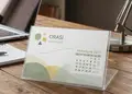 Επιτραπέζιο ημερολόγιο σε διάφανη πλαστική θήκη, με έγχρωμες σελίδες και επαγγελματικά σχέδια, ιδανικό για παραμετροποίηση.